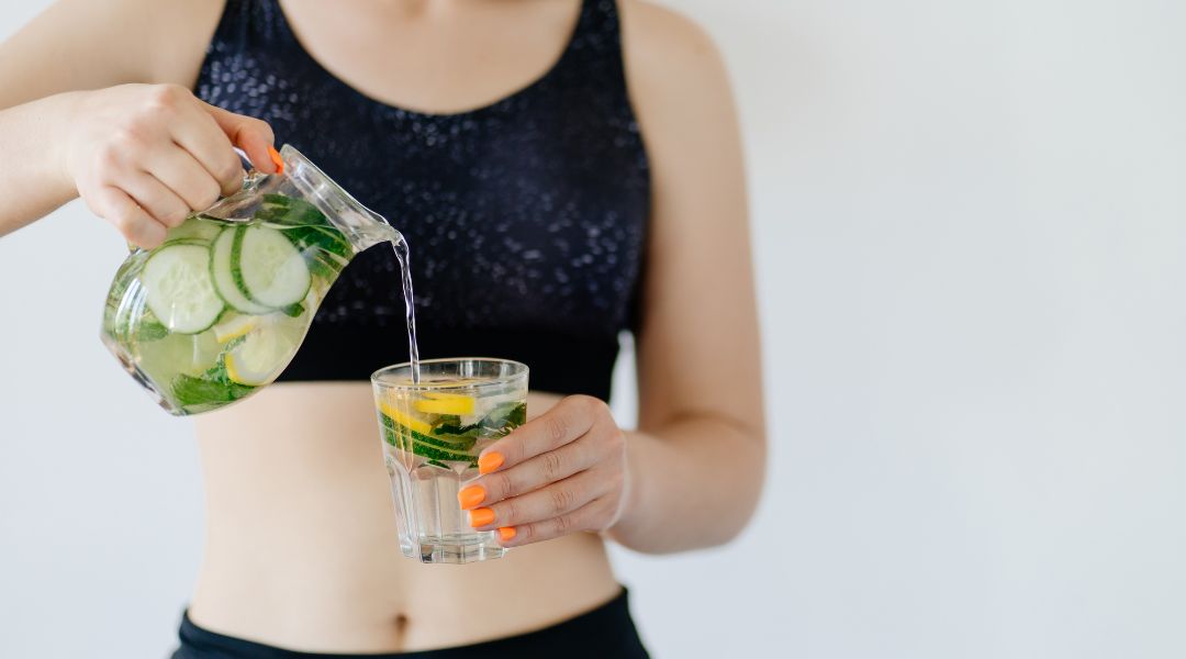 fit woman drinking infused water